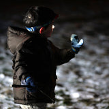 A child weraing a Princeton Tec Bot LED head torch, playing in the snow