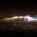 A caver using a Princeton Tec Apex LED head torch